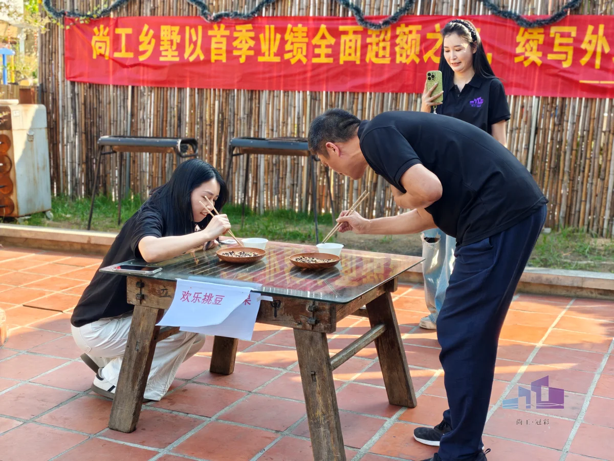 福建尚工乡墅装饰工程有限公司员工风采展示，新一组小组成员在团建活动中专注比拼“欢乐挑豆”游戏。