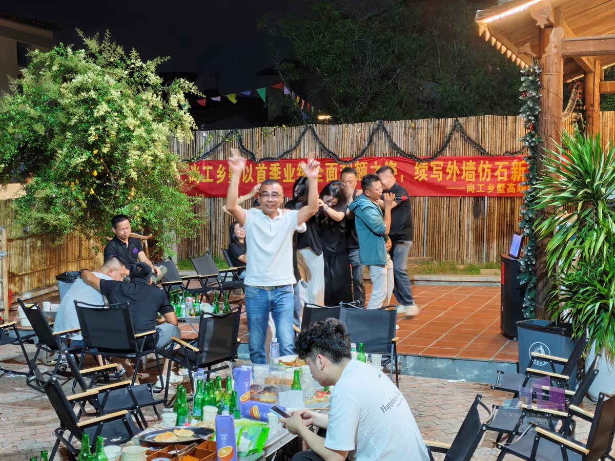 福建尚工乡墅装饰工程有限公司团队活动，员工在晚间户外拓展营地舞台前开怀欢呼，享受精彩的唱歌娱乐派对。