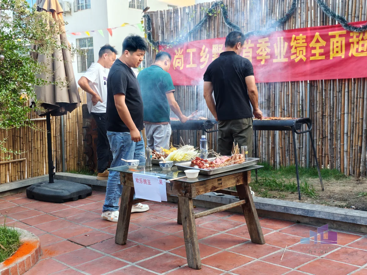 福建尚工乡墅装饰工程有限公司企业文化活动，员工在团建聚餐的户外露营地现场分工协作、准备烧烤美食。