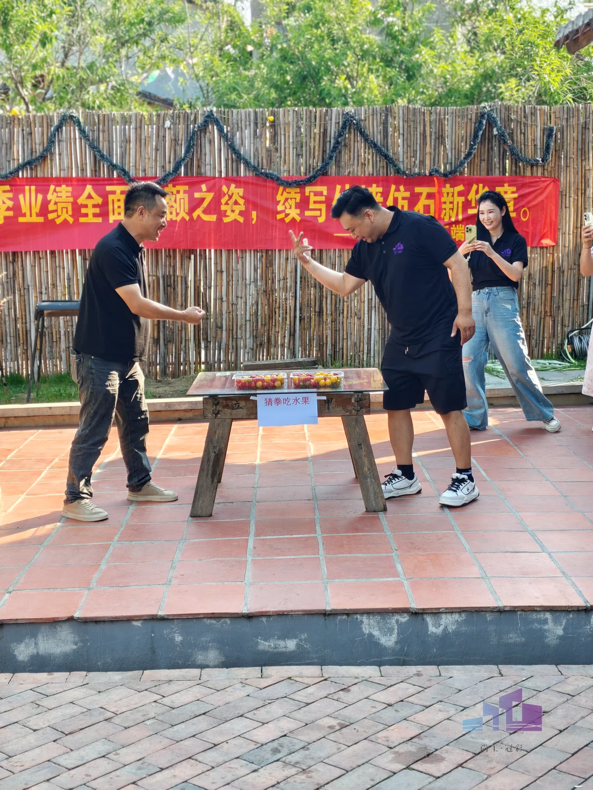 福建尚工乡墅装饰工程有限公司团队风采展示，员工在户外团建中进行趣味猜拳互动游戏。