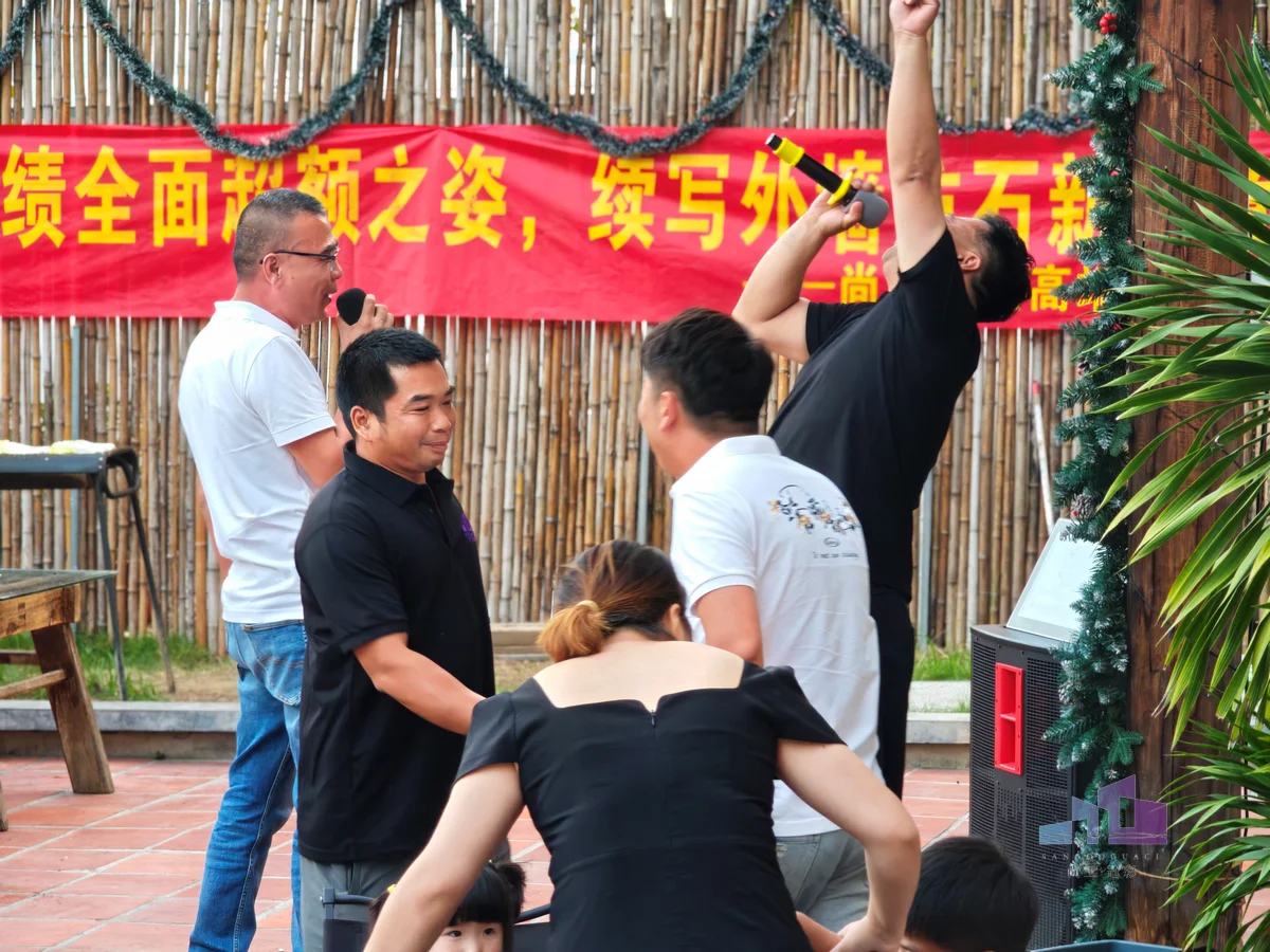 福建尚工乡墅装饰工程有限公司团队风采，男员工在团建拓展活动舞台上热烈互动，展现强烈的团队凝聚力。